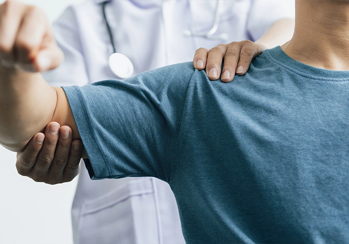 Doctor assisting a patient with a shoulder and arm mobility assessment