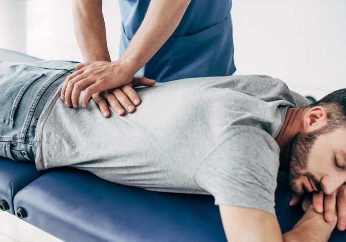 Chiropractor applying pressure to a patient’s lower back