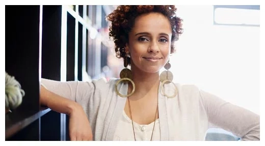 Person standing indoors with arms resting on shelves